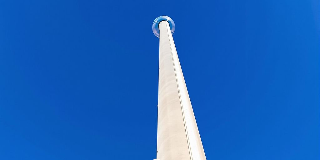 Brightly lit pylon structure against a clear sky.
