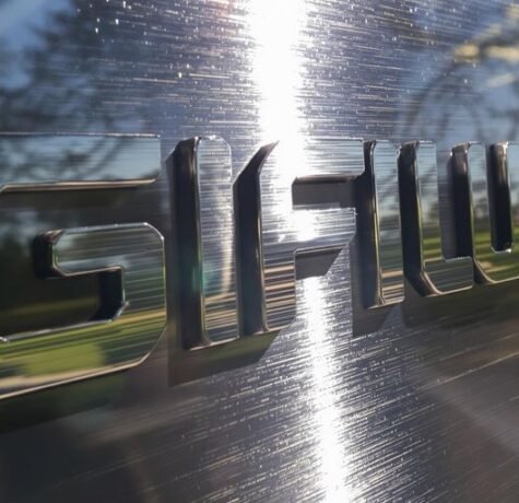 Elegant custom metal logo mounted outdoors.